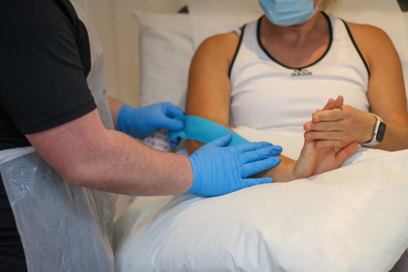 BOOST PHYSIO physiotherapist applying tape to a patient's forearm for tennis elbow