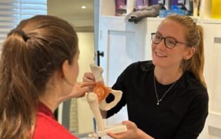 Women's health physiotherapist explaining to a patient the anatomy of the pelvis.