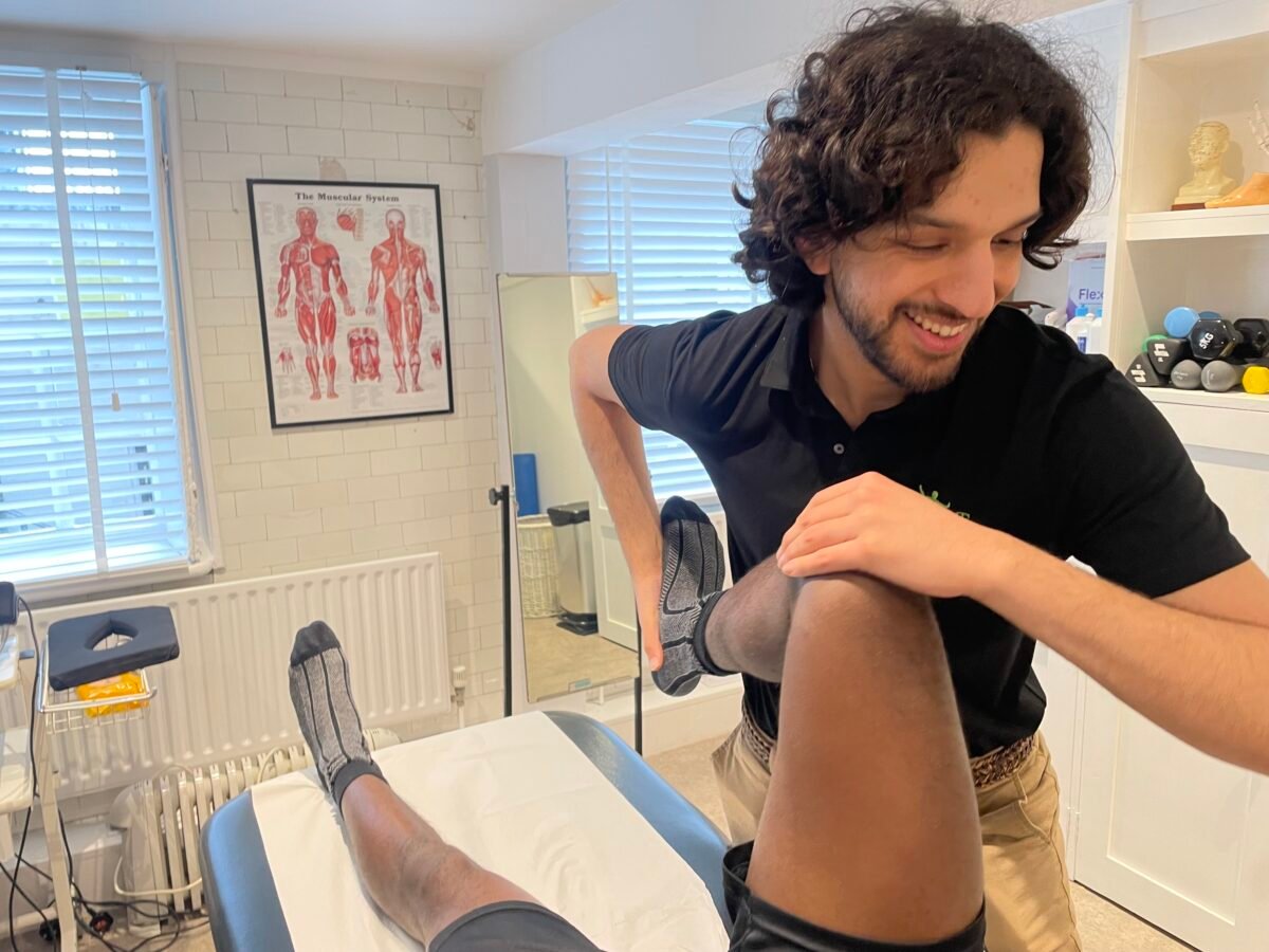 BOOST PHYSIO physiotherapist Aaran examining a patient's knee