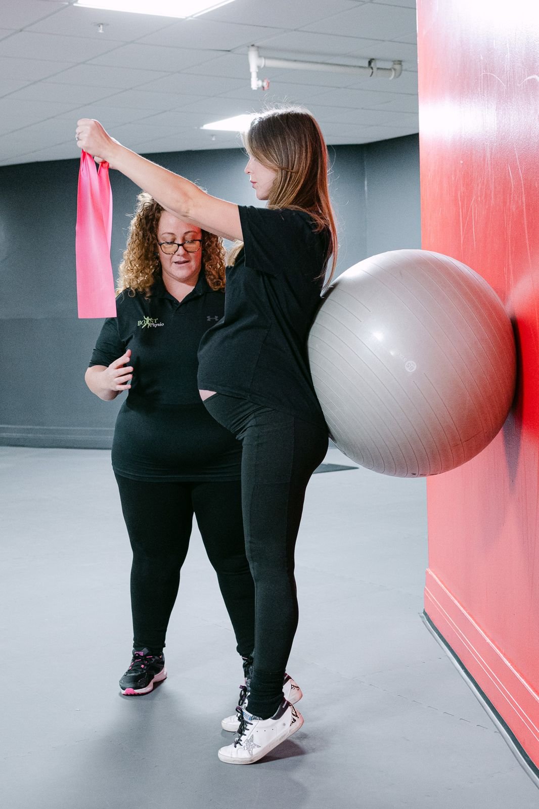 Physiotherapist coaching a resistance band exercise in a studio