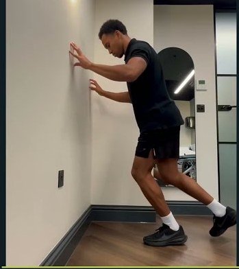 Otis demonstrating a bent knee calf raise to strengthen the soleus for shin splints rehab